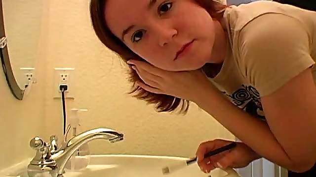 Redhead in tee shirt does her makeup